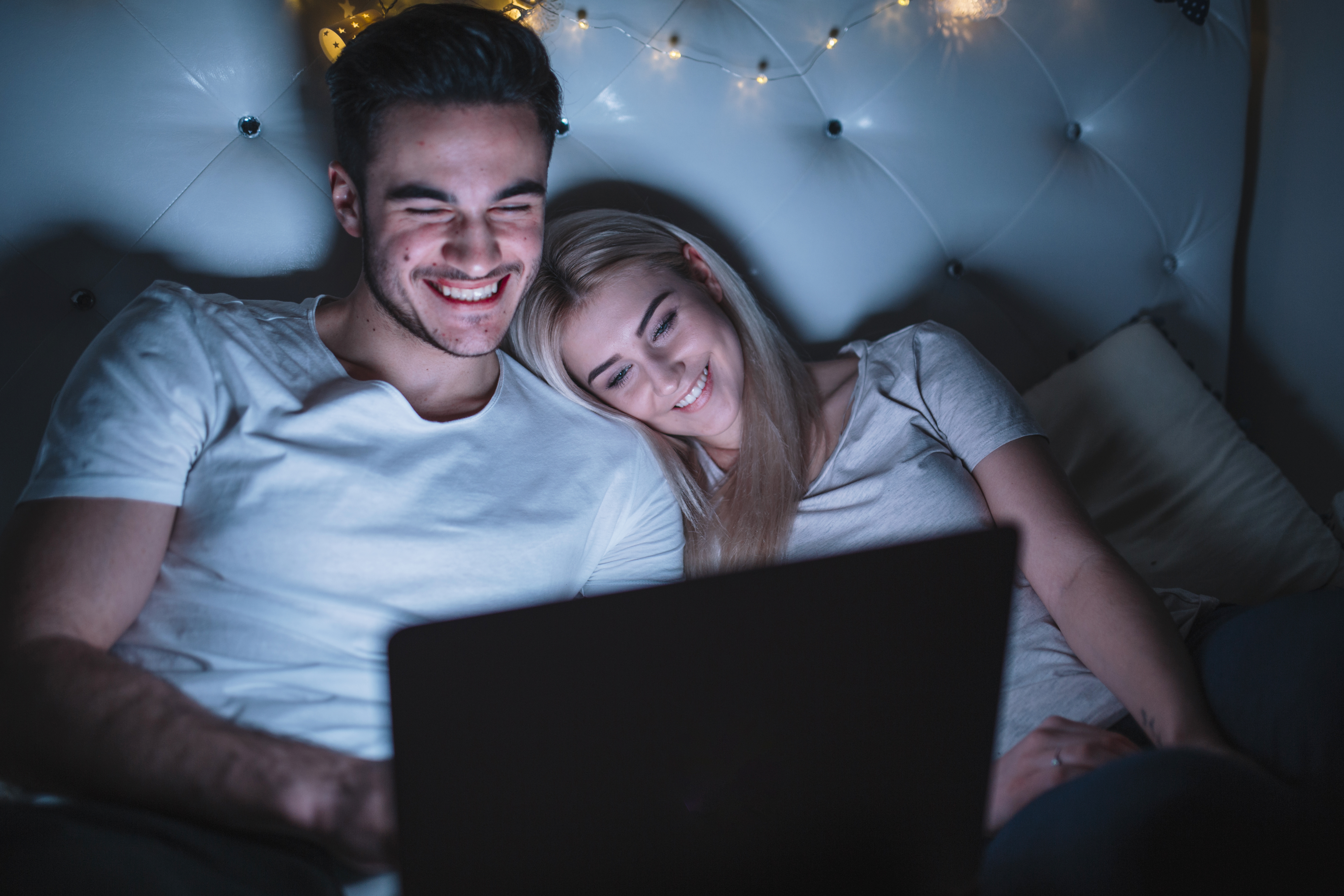 Couple watching film in bed with a laptop